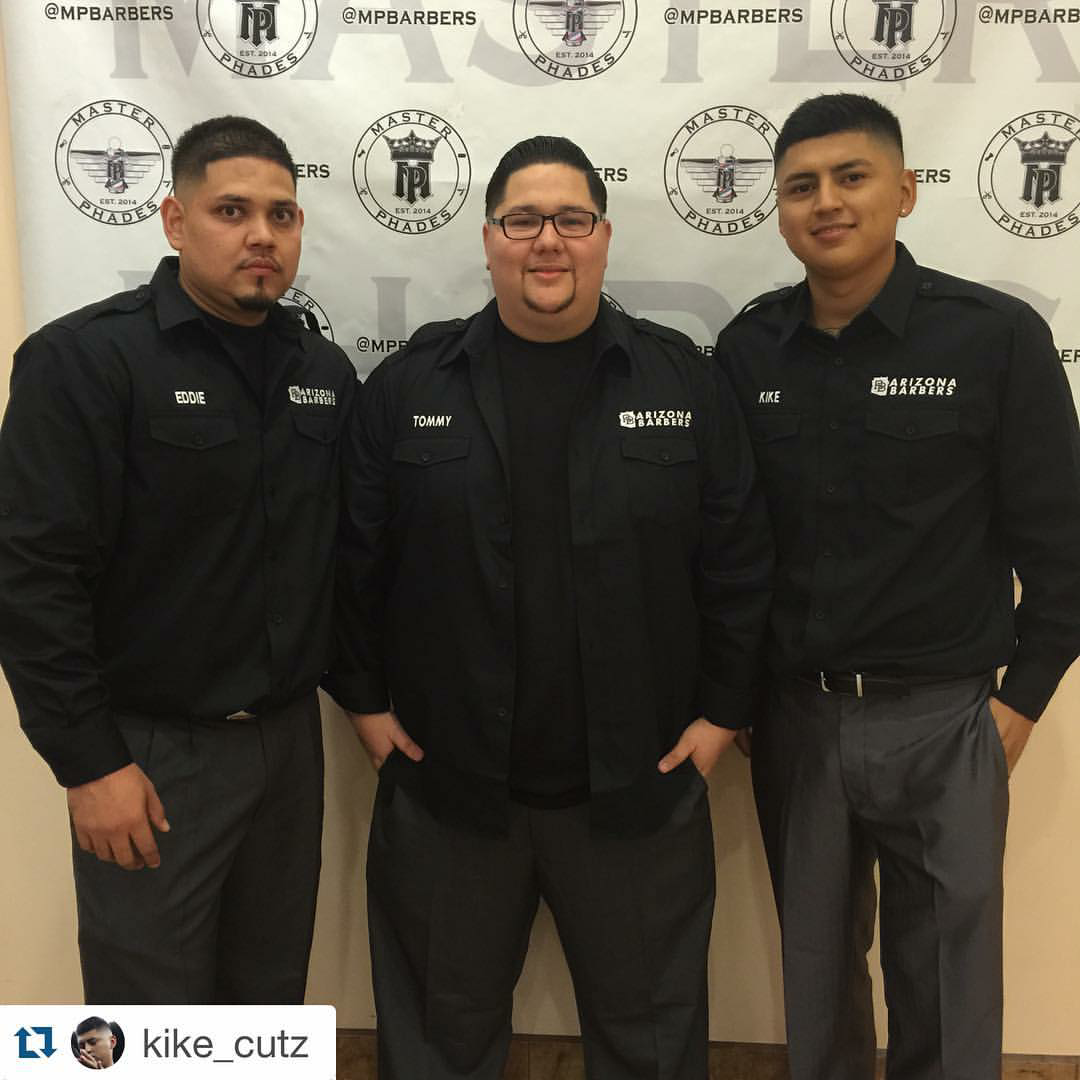 Three barbers in black Arizona Barbers uniforms at industry event