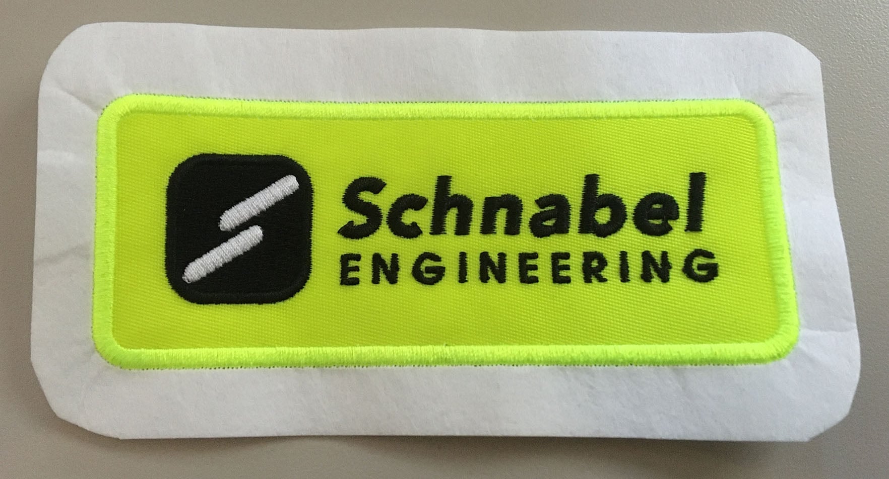 Sportex production collage with safety patches, embroidery samples, design workstations, client revisions, and project-management boards