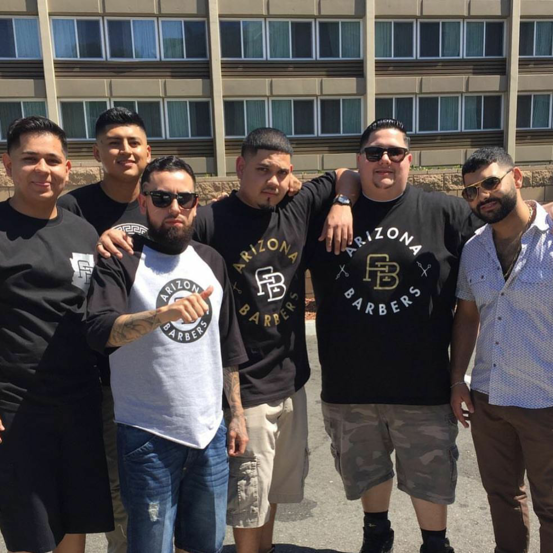 Arizona Barbers team members wearing branded t-shirts posing together outdoors