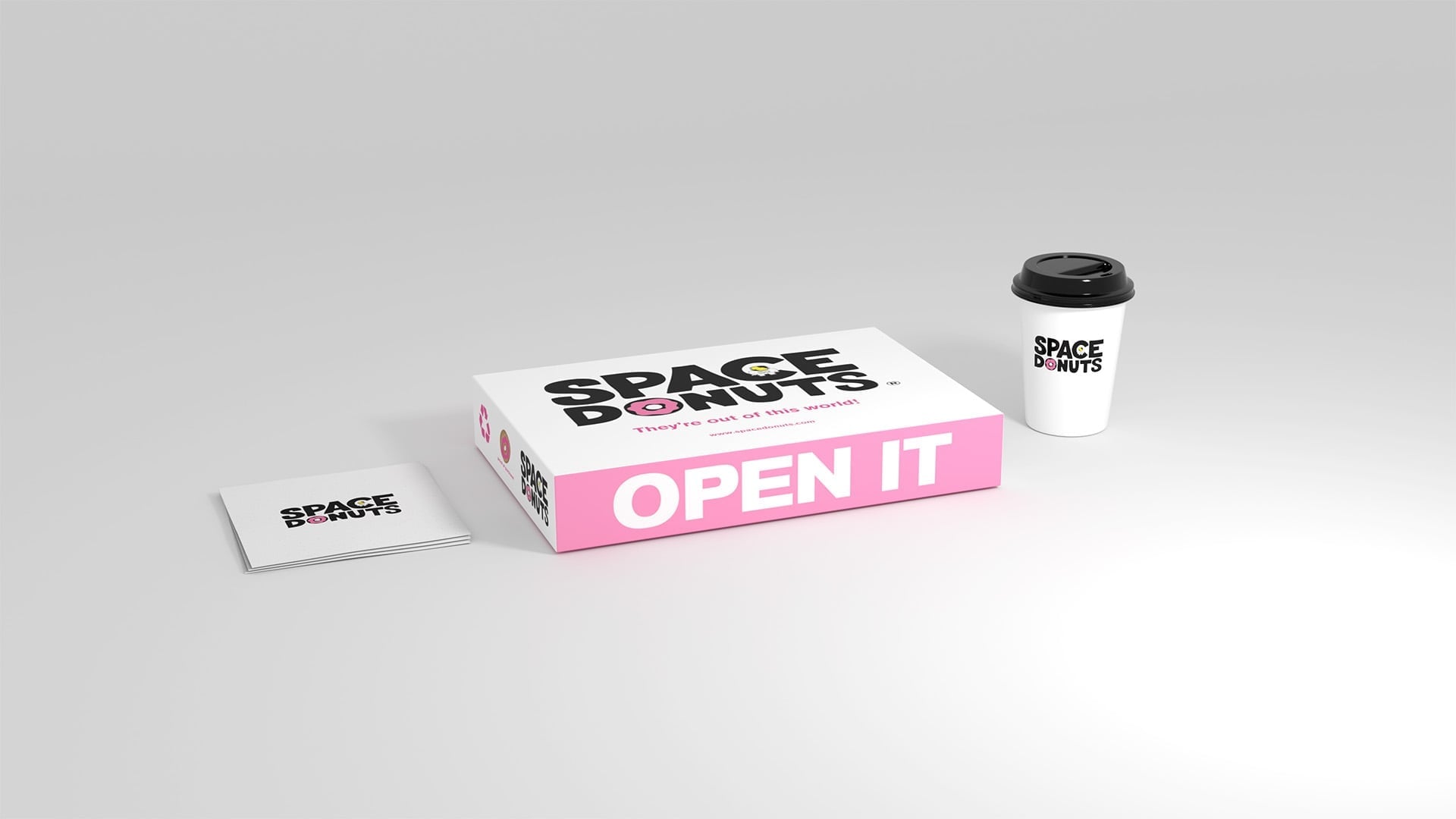 Space Donuts packaging set with white-and-pink donut box, branded coffee cup, and stacked business cards