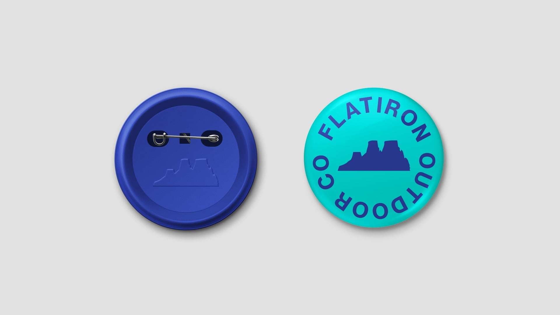 Collectible pin button set in blue and teal featuring Flatiron Outdoor Co. circular logo with mesa rock icon