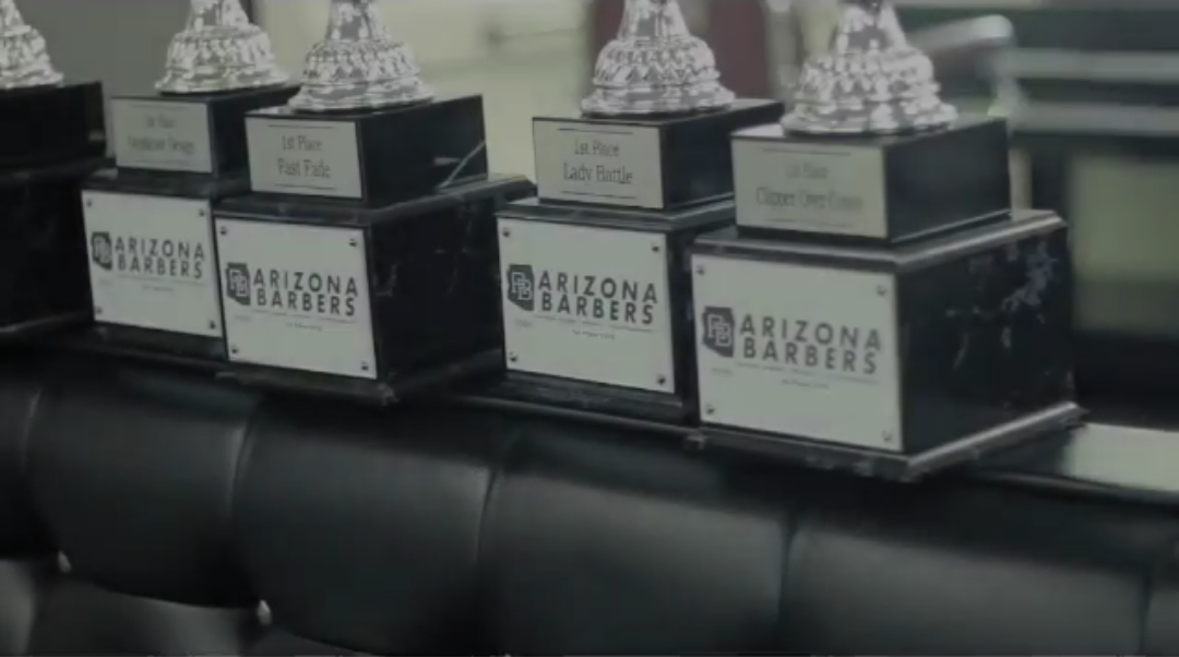 Row of competition trophies with Arizona Barbers branding on black bases